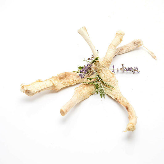 Dried root pieces arranged with sprigs of purple flowers and green leaves evoke nature's touch, akin to Wild Nosh Pets' craftsmanship in creating Freeze-Dried Bison Patellar Tendon treats.