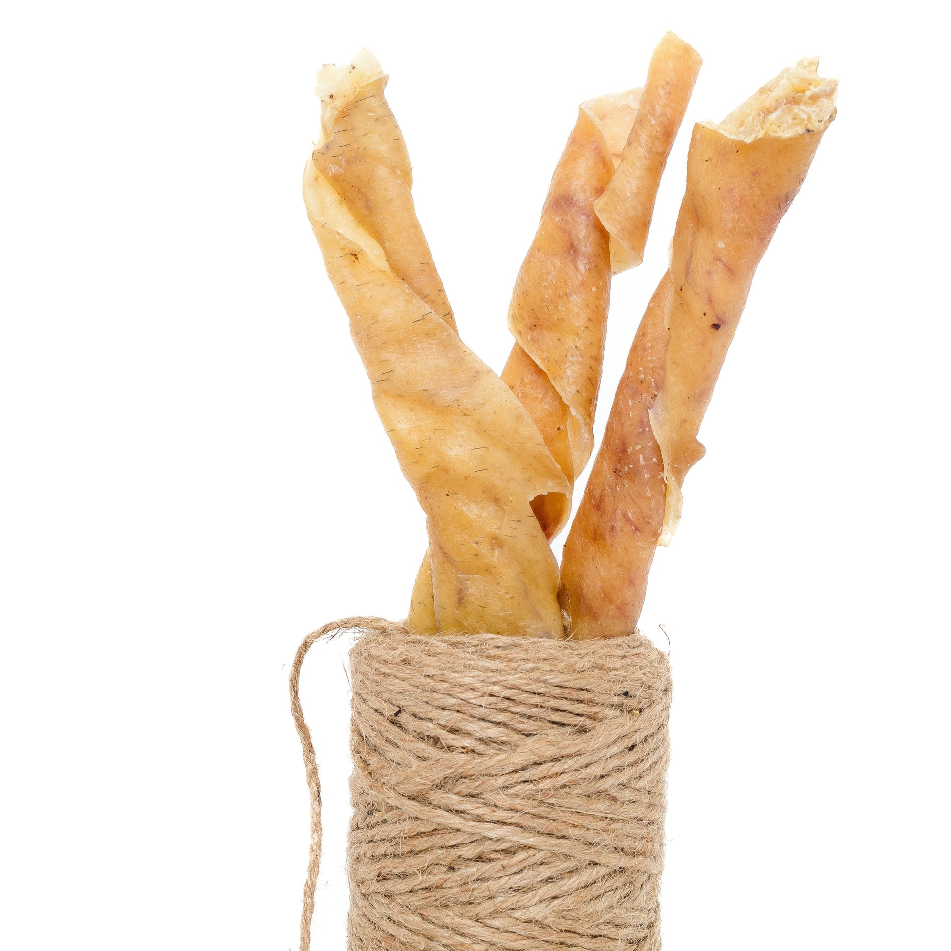 Three Heritage Breed Dehydrated Pork Rolls from Wild Nosh Pets stand upright in a spool of brown twine against a white background.