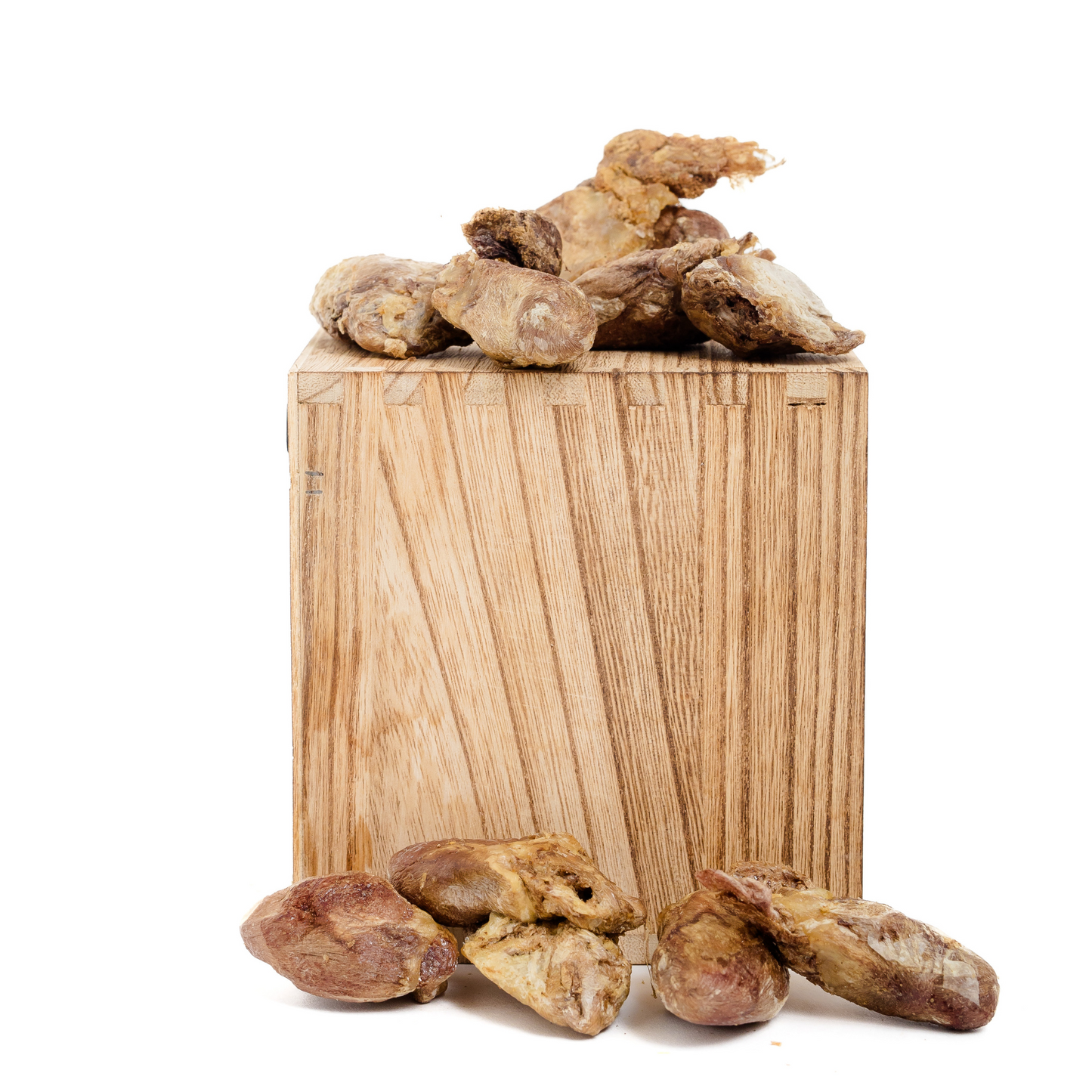 Wild Nosh Pets Freeze-Dried Duck Hearts 1 oz. are displayed on and around a rectangular wooden block against a white background.