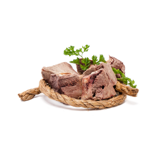 Raw beef bones with a garnish of parsley on a beige rope mat, isolated on a white background—perfect for pairing with Wild Nosh Pets Freeze-Dried Pork Hearts 3 oz. as exceptional training treats.