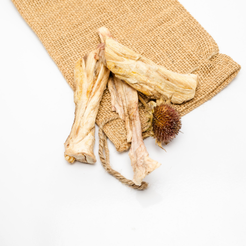 Three Freeze-Dried Bison Achilles Tendon pieces from Wild Nosh Pets on a burlap cloth pouch with a drawstring, ideal for teething puppies, placed on a white background.