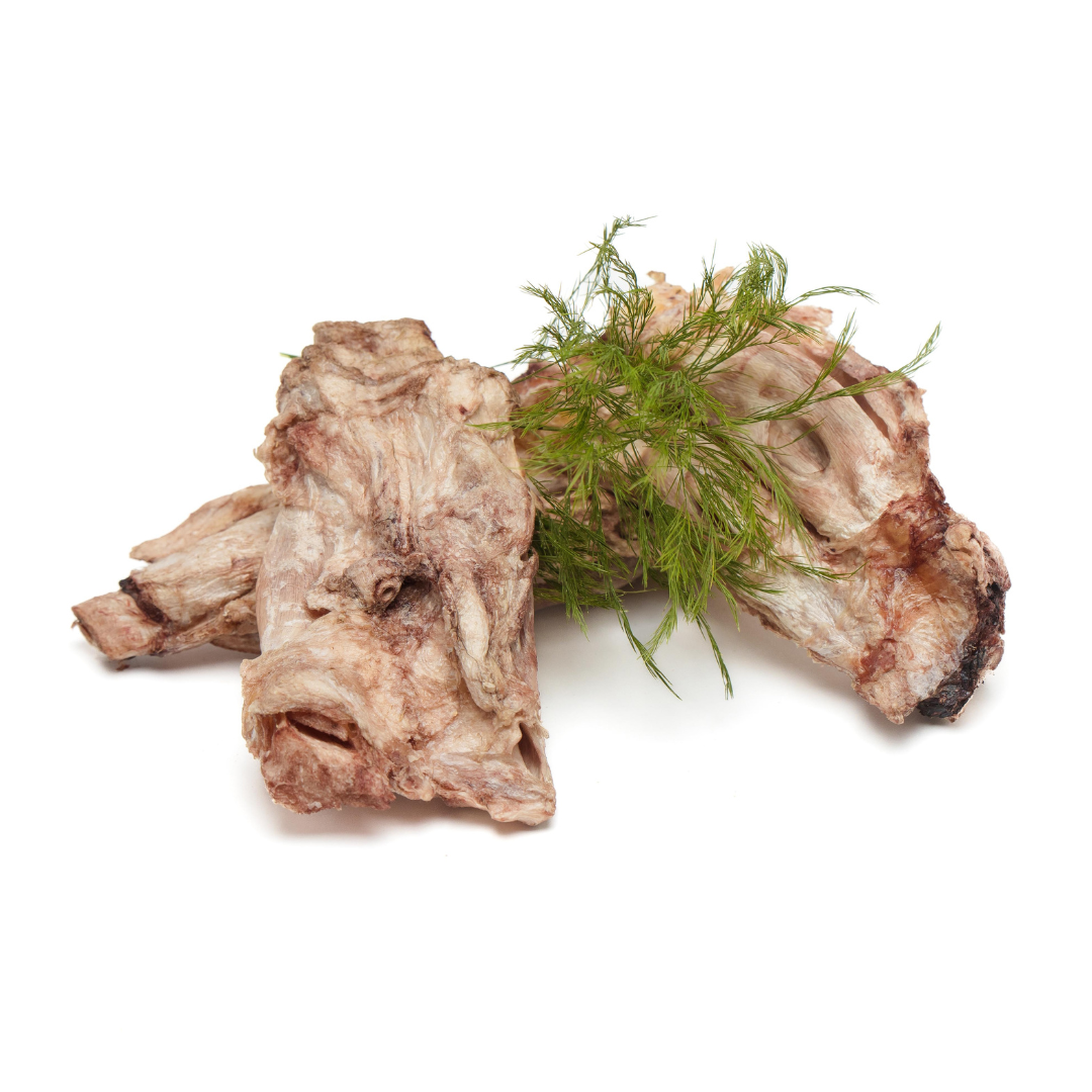 Two pieces of cooked meat garnished with a small bunch of fresh dill placed on a white background, reminiscent of the simplicity and natural beauty found in Wild Nosh Pets Freeze-Dried Bison Half Flexor Tendon.