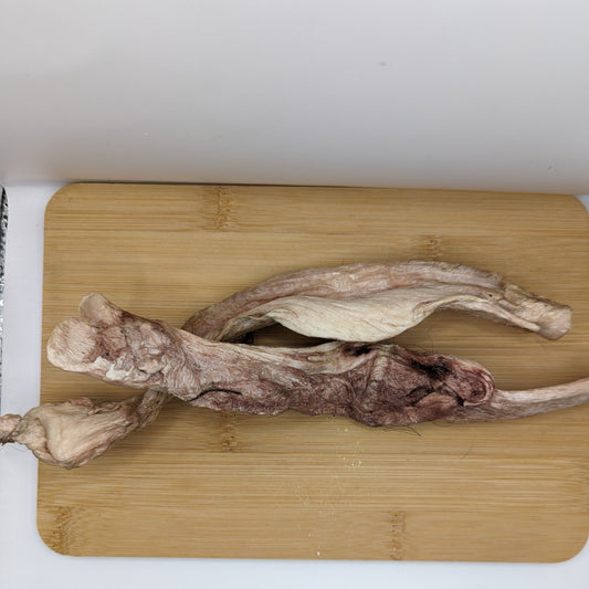 Dried fish bladder on a wooden cutting board, likely used as an ingredient in cooking or traditional medicine, similar to how Wild Nosh Pets' Freeze-Dried Bison Tibial Tendon is used for senior dogs and teething puppies.