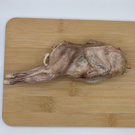 A protein-rich meal awaits as a Freeze-Dried Whole Quail from Wild Nosh Pets rests on a wooden cutting board.