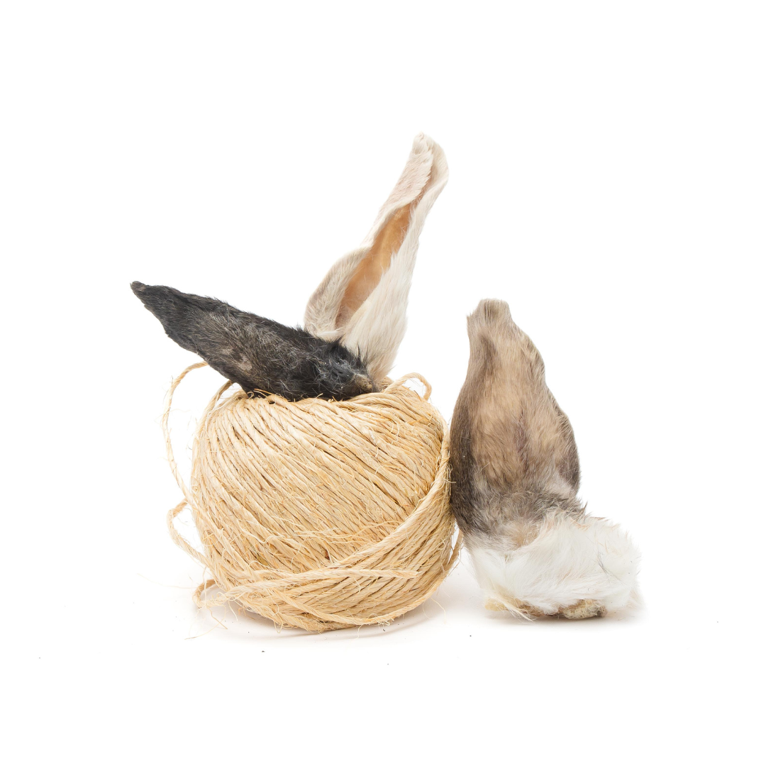 The Rabbit Ear by Wild Nosh Pets is pictured as a ball of tan twine with three pieces of animal fur attached, resembling rabbit ears.