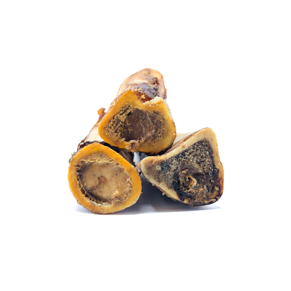 Four cross-sections of Wild Nosh Pets' Smoked Bison Marrow Bone are arranged together against a white background, providing a long-lasting chew that aids in cleaning teeth and gums.