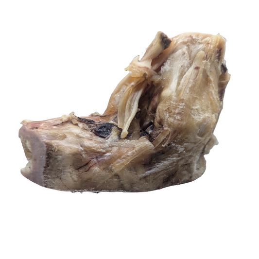 A substantial cooked portion of meat with visible fibers and a slightly pink interior, similar to Wild Nosh Pets' Smoked Bison Elbow, isolated on a white background.