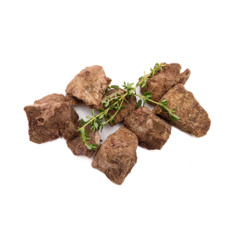 Several pieces of Wild Nosh Pets Freeze-Dried Bison Organ Medley 3oz garnished with sprigs of green herbs on a white background, offering a healthy treat that's as visually appealing as it is flavorful.