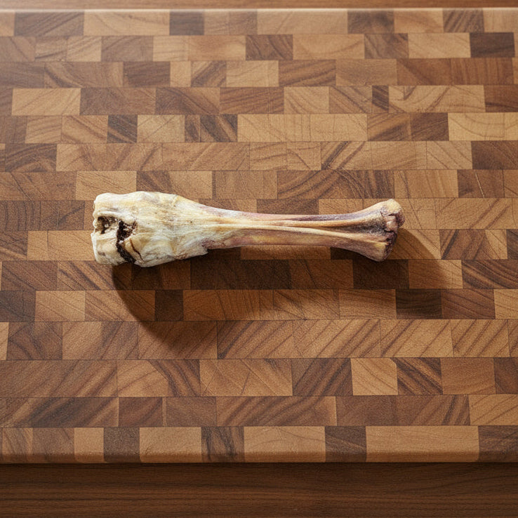 A Wild Nosh Pets Slow Roasted Bison Trotter Bone—Limited Edition, Field Harvested, 100% Grass Finished—sits atop a wooden cutting board, making the perfect all-natural dog chew.