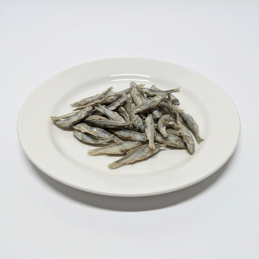 A small pile of freeze-dried minnows on a white plate. 