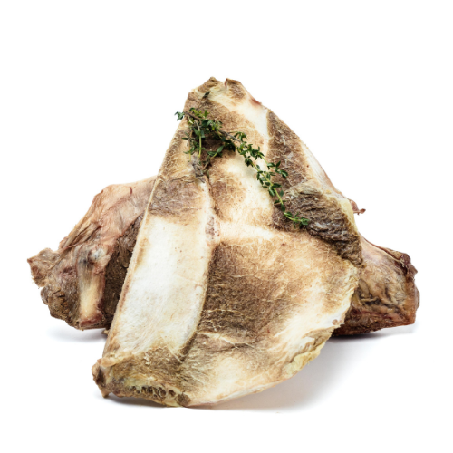 Two large raw Wild Nosh Pets Freeze-Dried Bison Scapula bones with sprigs of fresh thyme placed on top, perfect for senior dogs or teething puppies, isolated on a white background.