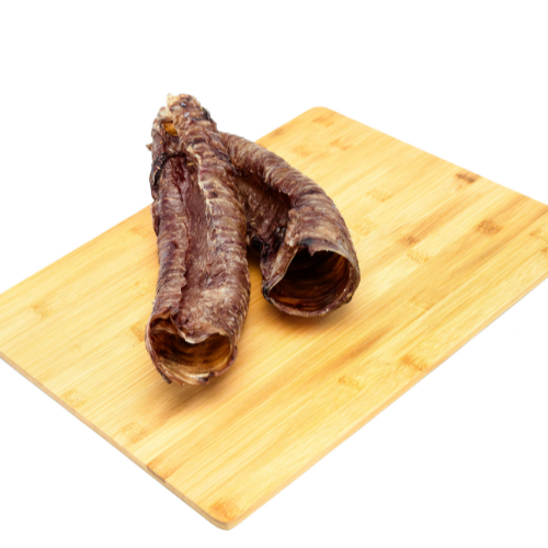 Two Wild Nosh Pets Bison Tracheas resting on a wooden cutting board, perfect for joint support or as healthy dog treats.